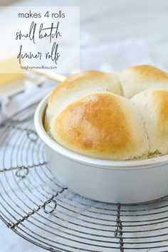 a white bowl filled with rolls on top of a wire rack