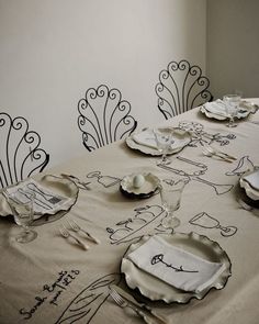 the table is set with white plates and silverware