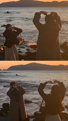 two people standing on rocks near the water with their backs to each other, looking into the distance