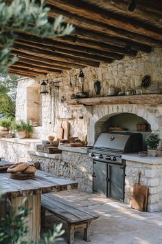 an outdoor kitchen with stone walls and grill