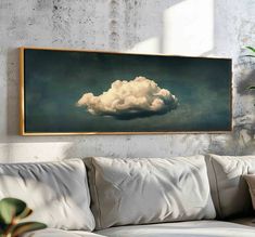 a white couch sitting in front of a painting on the wall