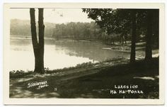 an old black and white photo of a lake in the middle of a wooded area