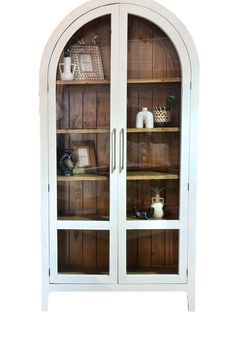 a white china cabinet with glass doors and shelves