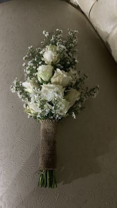 a bouquet of white flowers sitting on top of a bed