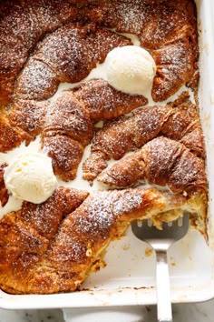 a close up of a pastry in a pan with ice cream on top and spoon