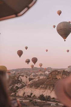 many hot air balloons flying in the sky