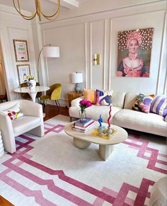 a living room filled with white couches and colorful pillows on top of a rug