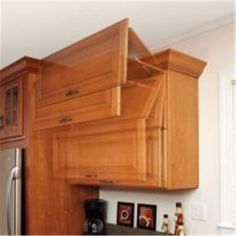 a kitchen with wooden cabinets and stainless steel refrigerator freezer in the center, along with pictures on the wall