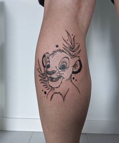 a tattoo on the leg of a person with a lion head and leaves around it