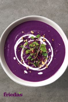 a white bowl filled with purple soup and garnish