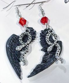 I am in love with Good Omens. Crowley and Aziraphale are the best so I had to make them earrings, you can choose crowley black wings, Aziraphale is white and I have a mix of both of them if you would like. The wings measure about two inches but are very light. Good Omens Earrings, Gothic Winged Jewelry Gift, Gothic Winged Jewelry For Gifts, Good Omens Jewelry, Handmade Black Fantasy Earrings, Black Wing-shaped Jewelry Gift, Wing-shaped Black Jewelry Gift, Black Fantasy Earrings, Black Wing-shaped Jewelry For Gifts