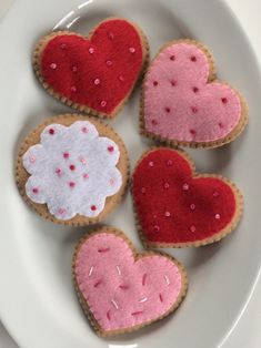 four heart shaped cookies on a white plate