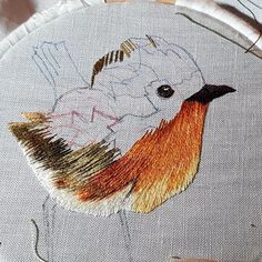 a close up of a embroidery on a piece of cloth with scissors in the background