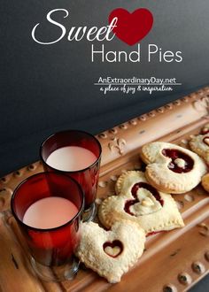 two cups of tea and some cookies on a tray with the words sweet hand pies