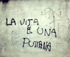 graffiti written on the side of a building in latin writing is black and white, with words that read la vita e dona potana