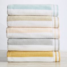 four towels stacked on top of each other in different colors and sizes, all folded neatly