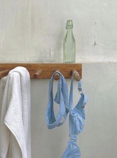 an old pair of bras hanging from a hook on a wall next to a bottle