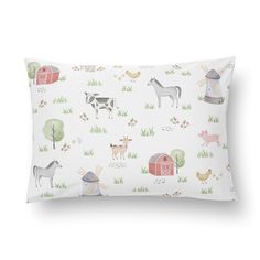 a white pillow with farm animals on it and a barn in the background is shown