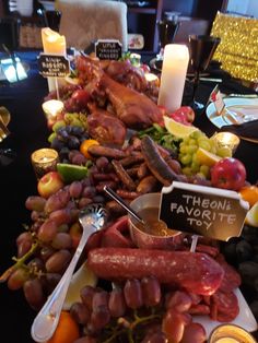 a table filled with lots of different types of food and candles on top of it