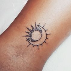 a small sun and moon tattoo on the ankle or foot, done by an artist