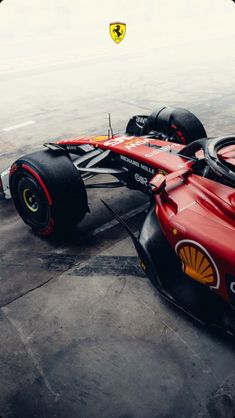 a red and black race car is parked on the tarmac with its wheels down