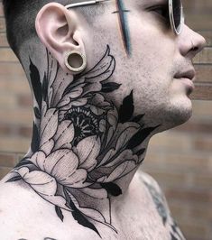 a man with tattoos on his face and neck