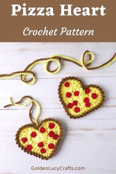 two crocheted heart shaped pizzas hanging from a string on a white wooden surface