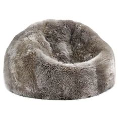 a large gray furry dog bed sitting on top of a white floor