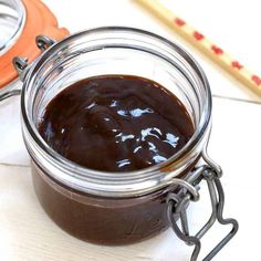 a glass jar filled with chocolate spread on top of a table