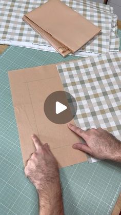 a man is making a piece of paper on a cutting board with scissors and tape