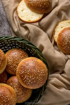 bread rolls in a basket with sesame seeds