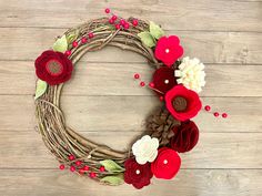 a wreath with flowers and leaves on a wooden surface, ready to be made into a decoration