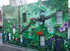 a large mural on the side of a building that has plants and flowers painted on it