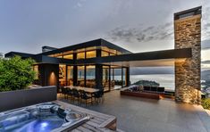 a hot tub sitting on top of a wooden deck next to a large patio area