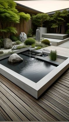 a garden with rocks and water features in the center, surrounded by wooden decking