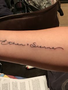 a person with a tattoo on their arm that says, john is shown in cursive writing