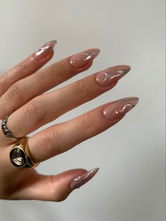 a woman's hand with long, shiny nails and gold rings on her fingers