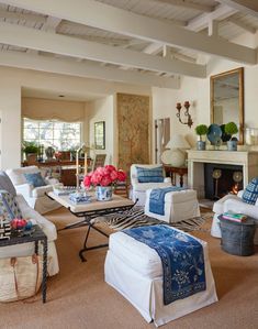 a living room filled with lots of furniture and flowers in vases on the table