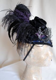 "This unique gothic-victorian masquerade headpiece was inspired by the luxurious Venice Carnival head-dresses. Created in a combination of midnight blue, black and purple. The teardrop base is covered with wonderful two-toned blue and black taffeta. I've used a gorgeous metal \"lace\" mask with rhinestones as the focal point. A glorious bouquet of flowers and feathers create a textured and one of a kind piece. A fluffy black ostrich, along with long iridescent rooster feathers and accents of pur Steampunk Mask Costume Accessories, Gothic Masks For Cosplay Carnival, Gothic Masquerade Mask For Carnival Cosplay, Gothic Masks For Halloween And Masquerade, Gothic Halloween Masks, Gothic Masks For Costume Party And Carnival, Gothic Masks And Prosthetics For Mardi Gras Cosplay, Gothic Costume Accessories For Theater And Carnival, Gothic Halloween Mask For Costume Party