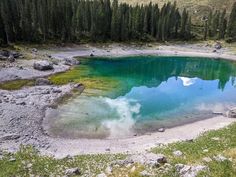 a blue lake surrounded by pine trees in the mountains