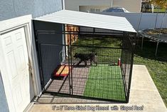 a dog in a cage on the outside of a house next to a door and grass area