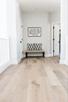 a white room with wood floors and a bench