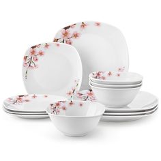 a white dinner set with pink flowers on it