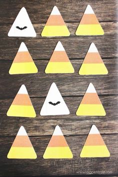 paper cut out to look like halloween decorations on a wooden surface with bats and pumpkins in the background