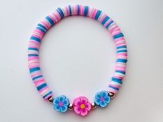 a pink and blue bracelet with flowers on it