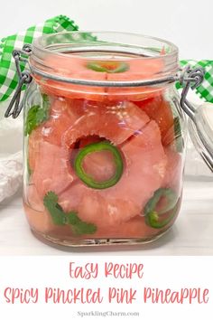 a jar filled with pink pineapple pickles and sliced pineapples in it