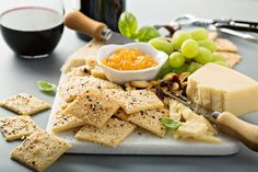 cheese, crackers and grapes on a cutting board