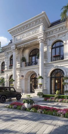 an old car is parked in front of a large white building with many windows and balconies