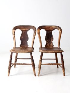 two old wooden chairs sitting next to each other