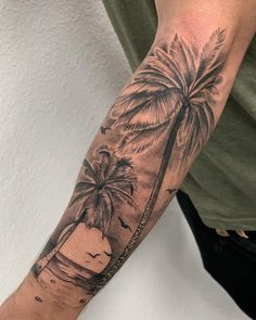 a man's arm with a palm tree and beach scene tattoo on the forearm